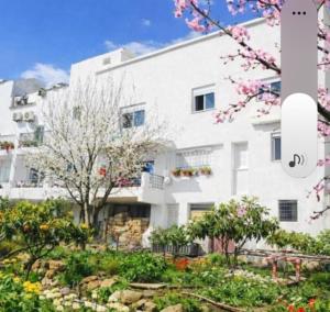 a white building with a garden in front of it at Le Jardin Aparthotel in Taza