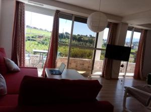 a living room with a couch and a laptop on a table at Le Jardin Aparthotel in Taza