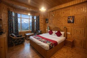 a bedroom with a bed in a room with wooden walls at Woods Villa Cottages Manali - 1,2,3,4 Bedrooms Luxury Cottages & Villa Available in Manali with Scenic Mountain View, Manali in Manāli