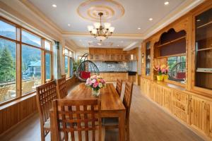 a dining room with a wooden table and chairs at Woods Villa Cottages Manali - 1,2,3,4 Bedrooms Luxury Cottages & Villa Available in Manali with Scenic Mountain View, Manali in Manāli
