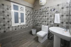 a bathroom with a toilet and a sink at Woods Villa Cottages Manali - 1,2,3,4 Bedrooms Luxury Cottages & Villa Available in Manali with Scenic Mountain View, Manali in Manāli