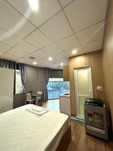 a room with a bed and a kitchen with a view at Linh's House in Danang