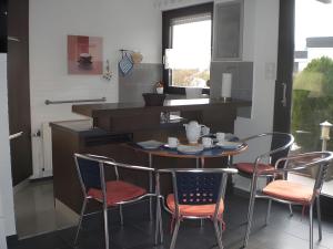 a kitchen with a table and chairs in a kitchen at Nordseeferienbungalow in Butjadingen