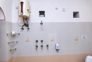 a bathroom with a shower with a hair dryer and a phone at Alivaa Heritage Lotwara Fort - Near Shri Mehandipur Balaji Temple in Dausa +16 photos
