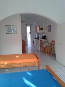 a living room with a table and a kitchen at Angelos Rooms in Myrtos
