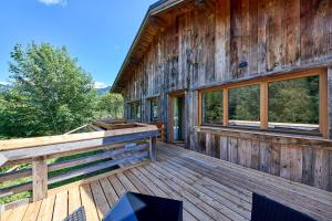 a cabin with a large deck with windows at Locanda Boton D'Oro in Auronzo di Cadore