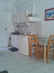 a kitchen with a table and chairs and a sink at Angelos Rooms in Myrtos +25 photos