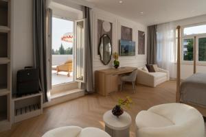 a bedroom with a bed and a living room at Heritage Hotel Zagreb Dubrovnik in Dubrovnik