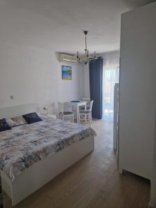a bedroom with a bed and a table with chairs at Vila Lidus in Brist