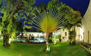 a palm tree in the yard of a house at Villa Costa Sanur in Sanur