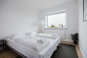 a white bedroom with a large bed with towels on it at Lovely cozy apartment in Søborg