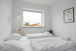 two white beds in a white room with a window at Lovely cozy apartment in Søborg
