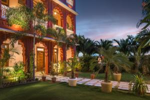 a house with palm trees in front of it at Eartham Stays, Pushkar in Pushkar