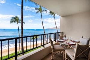 a balcony with a table and chairs and a view of the beach at SUGAR BEACH RESORT, #421 in Kihei
