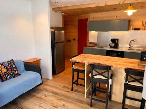 a kitchen with a table and a couch in a room at Le Plainpalais - 4pers - Balcon vue Montagnes in Les Déserts