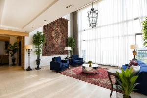 a living room with blue furniture and a large window at SkyHouse by Ace Luxe in Islamabad