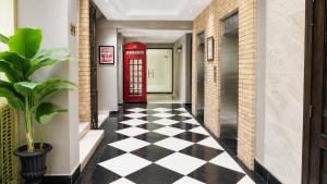 a hallway with a red phone booth and a checkered floor at SkyHouse by Ace Luxe in Islamabad