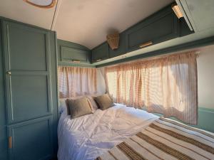a bedroom with a bed and a window at Caravana Lobo Camp in Boca de Huérgano