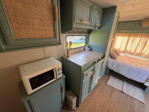 a small kitchen in an rv with a microwave at Caravana Lobo Camp in Boca de Huérgano