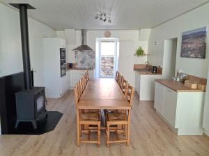 a kitchen and dining room with a table and a stove at La belle étoile in Saugues