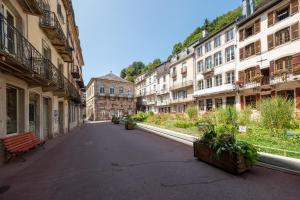 an empty street in a city with buildings at La Petite Caille - Appartement 10 in Plombières-les-Bains +22 photos