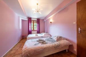 two beds in a room with pink walls at La Petite Caille - Appartement 10 in Plombières-les-Bains