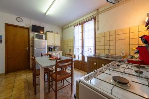 a kitchen with a table and a stove top oven at La Petite Caille - Appartement 10 in Plombières-les-Bains