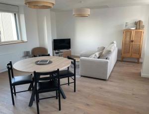 a living room with a table and a couch at appartement la pause coté mer in Santec