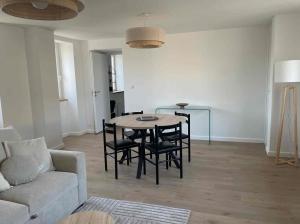 a living room with a table and chairs and a couch at appartement la pause coté mer in Santec +10 photos