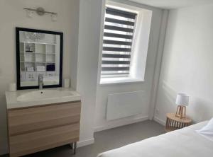 a white bedroom with a sink and a window at appartement la pause coté mer in Santec
