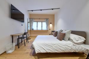a bedroom with a bed and a desk in a room at Locanda Boton D'Oro in Auronzo di Cadore
