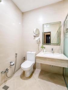 a bathroom with a toilet and a sink and a mirror at Hotel Meenakachi Resort in Brahmapur