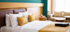 a hotel room with a bed and a chair at Hotel Meenakachi Resort in Brahmapur