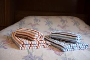 two stacks of towels sitting on top of a bed at Appartement 5 - La Petite Caille in Plombières-les-Bains