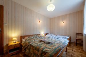 a bedroom with two beds and two lamps in it at La Petite Caille - Appartement 4 in Plombières-les-Bains