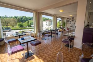 Hôtel Brun في Saint-Lattier: مطعم به طاولات وكراسي ونافذة كبيرة