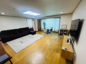 a living room with a couch and a table at Pinkliey House in Ilsan-yŏk