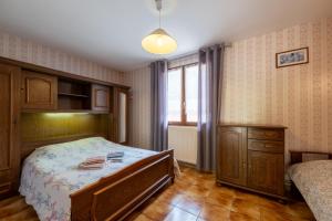 a bedroom with a bed and a dresser and a window at Appartement 5 - La Petite Caille in Plombières-les-Bains