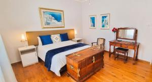 a bedroom with a bed and a table and a mirror at Protea House in Graaff-Reinet