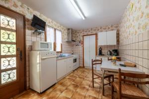 a kitchen with a table and a white refrigerator at Appartement 5 - La Petite Caille in Plombières-les-Bains
