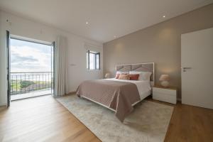 a bedroom with a bed and a large window at Ponta do Pargo Village - By WeHostMadeira in Ponta do Pargo