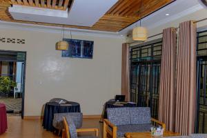 a room with two tables and chairs and windows at RP Gorilla Guest & Coffee in Taba