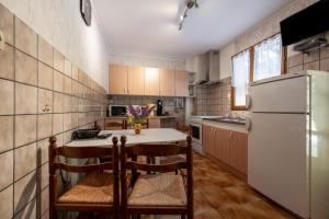 a kitchen with a white refrigerator and a table and chairs at La Petite Caille - Appartement 4 in Plombières-les-Bains