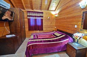 a bedroom with a bed in a wooden cabin at סוויטות חלב ודבש in Kefar Zetim +48 photos