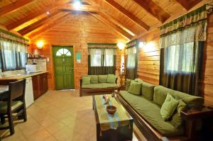 a living room with a green couch in a wooden house at סוויטות חלב ודבש in Kefar Zetim