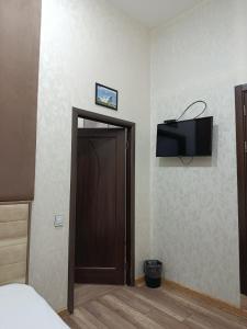 a room with a door with a television on the wall at Baku City Inn Boutique Nizami Hotel in Baku