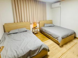a bedroom with two beds and a lamp in it at Pinkliey House in Ilsan-yŏk
