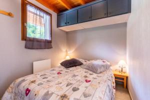 a bedroom with a bed and a window at Les Balcons de St So Appartement B in Saint-Sorlin-dʼArves