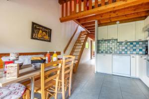 a kitchen with a table and a staircase in a house at Les Balcons de St So Appartement B in Saint-Sorlin-dʼArves