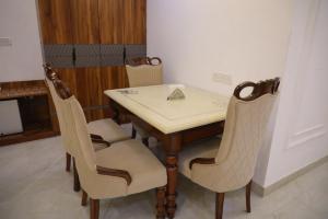a dining room table with two chairs and a table and chairsuggest at Shanti Sewa Dham in Chhatikara
